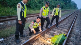 Anggota Polsek Kandeman dan petugas KAI tiba di lokasi kejadian warga setempat yang tewas terlindas kereta api di jalur KM 76+800 Desa Tegalsari, Senin (27/4/26).