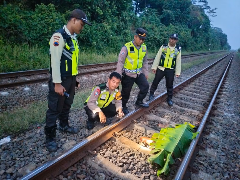 Anggota Polsek Kandeman dan petugas KAI tiba di lokasi kejadian warga setempat yang tewas terlindas kereta api di jalur KM 76+800 Desa Tegalsari, Senin (27/4/26).