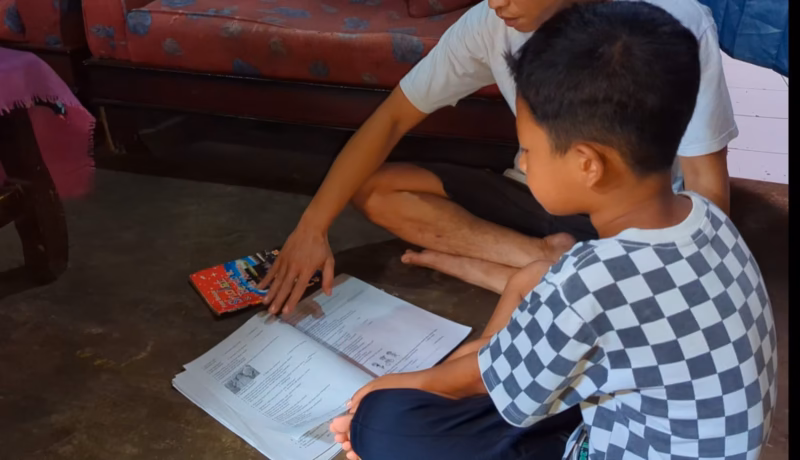 Syaifudin Azim (9) belajar di rumah ditemani ayahnya setelah kasus dugaan perundungan di sekolah dilaporkan ke polisi dan sudah dilakukan klarifikasi, Sabtu (2/5/26).