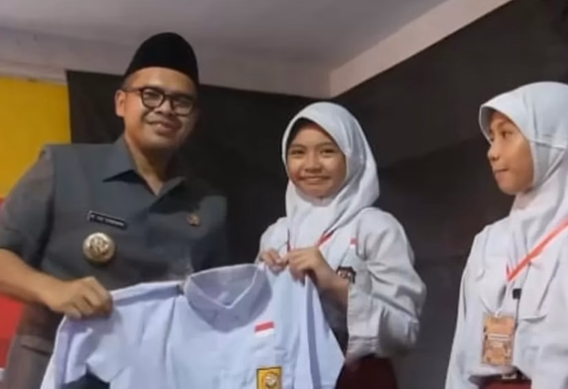Bupati Batang M Faiz Kurniawan secara simbolis menyerahkan seragam kepada siswi penerima, Rabu (10/6/26). Foto : Istimewa