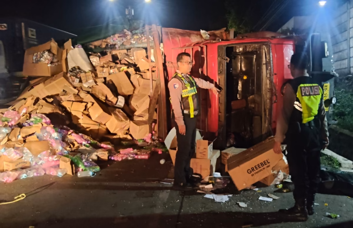 Dua anggota polisi dari Satlantas Polres Batang di depan truk yang terguling akibat kecelakaan di jalur Pantura, Selasa (9/6/26). Foto : Istimewa