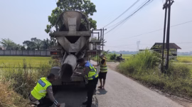 Polisi dibantu warga menambal lubang jalan di beberapa ruas jalur utama untuk mengurangi resiko kecelakaan, Senin (15/6/26). Foto : Istimewa