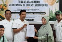 Perwakilan dari Food Bank dan pemilik dapur MBG memperlihatkan dokumen hasil penandatanganan komitmen kerja sama di bidang distribusi pangan berlebih di SPPG, Sabtu (11/7/26).