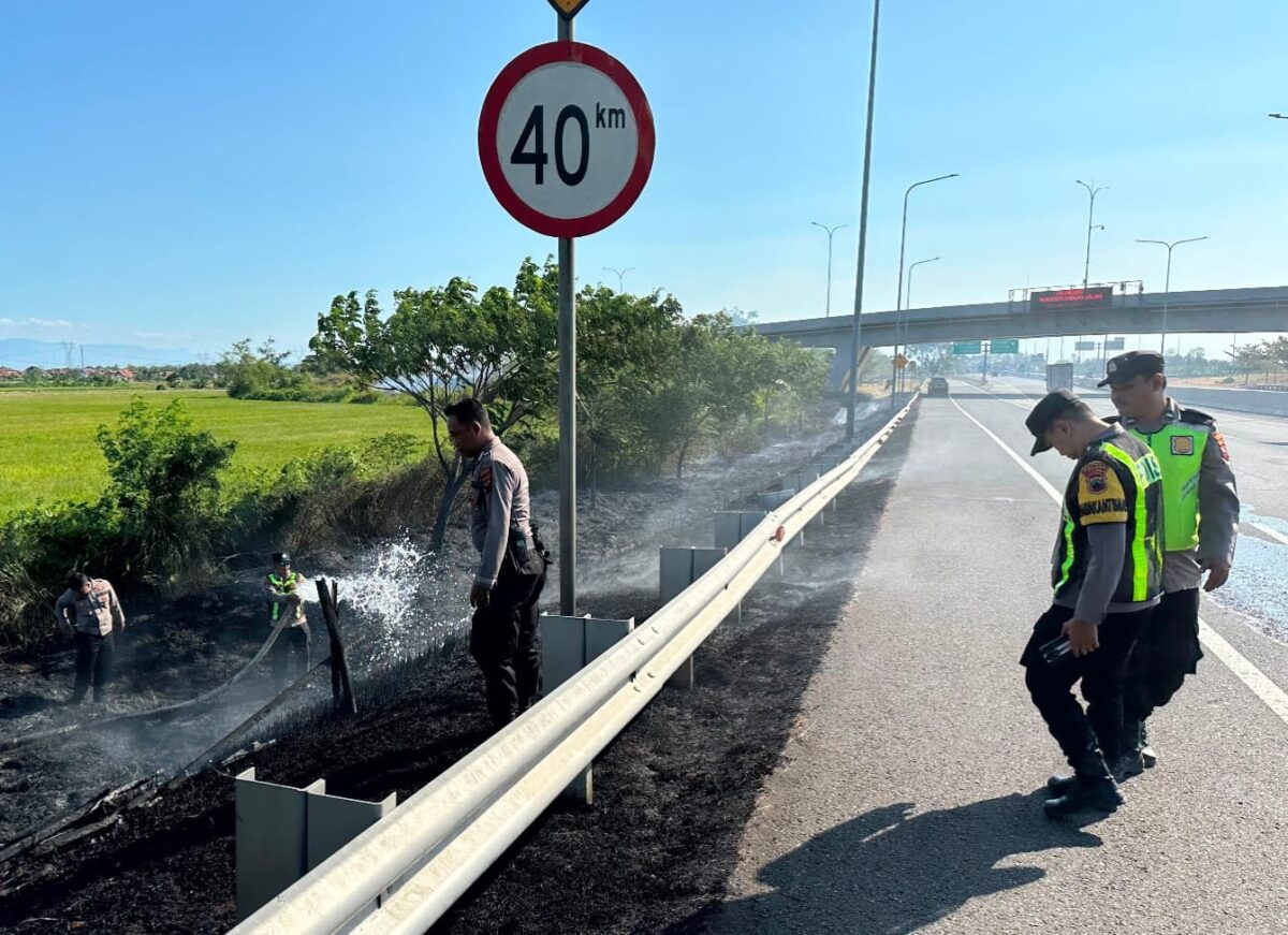 Petugas kepolisian memadamkan api yang membakar lahan di dekat Tol Pejagan, Kabupaten Brebes, Kamis (23/7/26) lalu. Foto : Istimewa