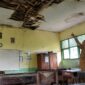 Seorang guru menunjukkan ruangan kelas yang mengalami kerusakan berat, Selasa (28/7/26). Foto : Ilustrasi AI