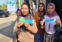 Warga Desa Siwatu yang bersebelahan dengan lokasi acara kunjungan Presiden RI Prabowo Subianto memperlihatkan kupon MBG dan undian sepeda listrik dari penyelenggara acara, Kamis (30/7/26).