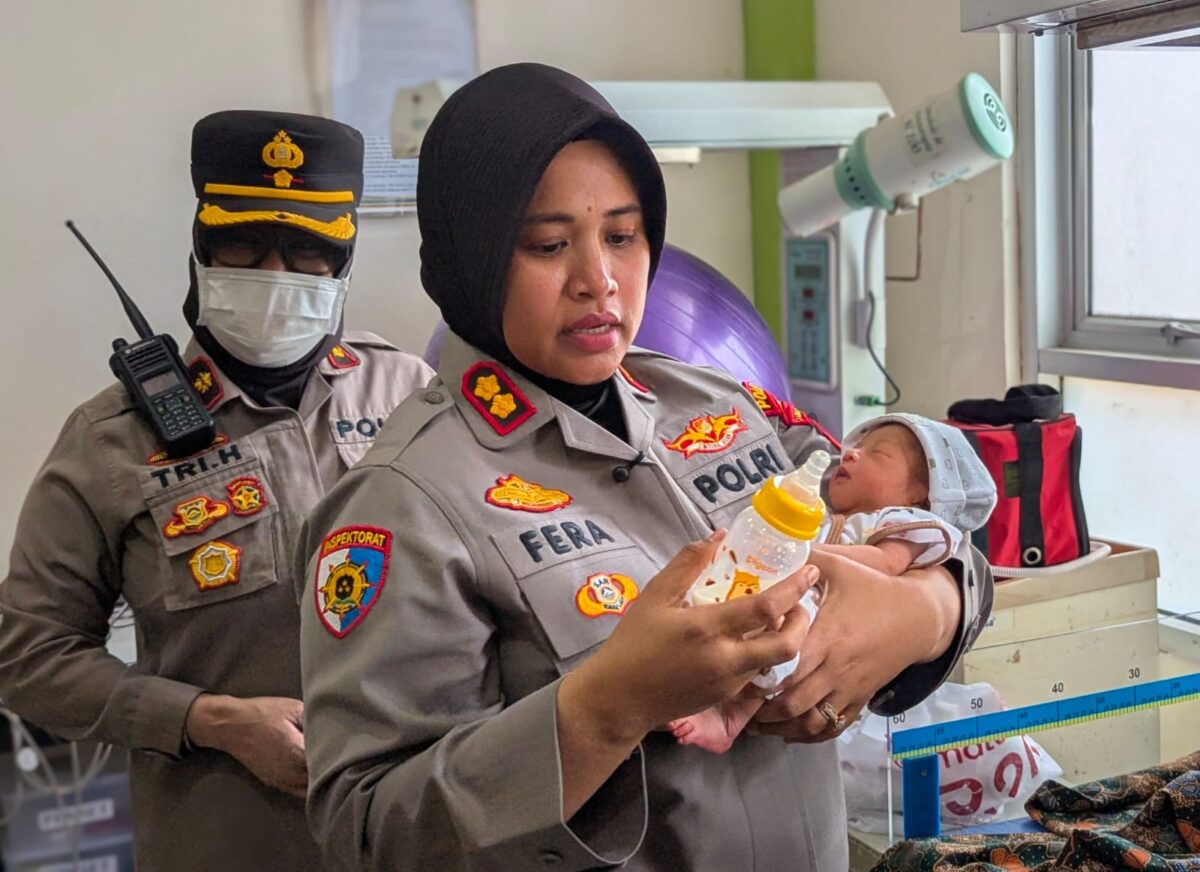Kapolres Pekalongan Kota AKBP Dies Ferra Ningtias menggendong bayi usia lima hari yang diberi nama panggilan Arya saat menjenguk di Puskesmas Sokorejo usai dievakuasi oleh anggotanya dari lokasi temuan di samping terminal, Selasa (4/8/26).