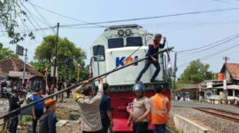 Petugas berusaha menyingkirkan tiang jaringan internet yang roboh melintang di tengah rel kereta api, Jumat (7/8/26). Foro : Istimewa