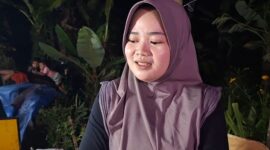 Amalia (23) memanfaatkan keramaian gebyar lampu hias di Desa Kandang untuk berjualan mencari tambahan penghasilan, Sabtu (8/8/26).
