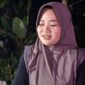 Amalia (23) memanfaatkan keramaian gebyar lampu hias di Desa Kandang untuk berjualan mencari tambahan penghasilan, Sabtu (8/8/26).