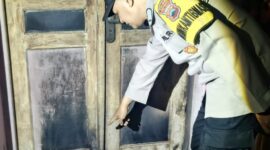 Polisi menunjukkan pintu depan rumah korban yang diduga seperti bekas dibakar dengan sengaja oleh orang tidak dikenal, Selasa (11/8/26). Foto : Istimewa