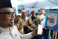 Bupati Batang M Faiz Kurniawan melakukan scan QRIS untuk ikut berdonasi di Booth BI Tegal dalam kegiatan Pekan QRIS Nasional 2026 sekaligus resepsi peringatan HUT Ke-81 Kemerdekaan RI yang berlangsung di Jalan Veteran, Senin (15/8/26) malam.