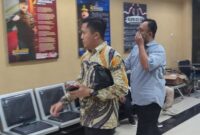 Salah satu tersangka mantan Dirut PDAM Muhammad Iqbal dengan menutup sebagian mukanya masuk Ruangan Tahap II Kejari Kota Pekalongan didampingi penasehat hukumnya Jimmy Muslimin, Selasa (18/8/26) malam.