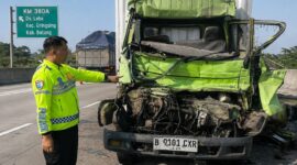 Polisi menunjukkan kondisi depan truk boks yang menabrak truk lain di depannya hingga menyebabkan pengemudinya tewas saat kejadian berlangsung, Kamis (20/8/26) pagi. Foto: Modifikasi AI