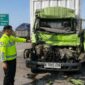 Polisi menunjukkan kondisi depan truk boks yang menabrak truk lain di depannya hingga menyebabkan pengemudinya tewas saat kejadian berlangsung, Kamis (20/8/26) pagi. Foto: Modifikasi AI
