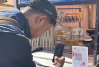 Seorang pengunjung sedang menscan barkode transaksi online di Dieng Culture Festival 2026 Desa Dieng Kulon, Minggu (30/8/26).