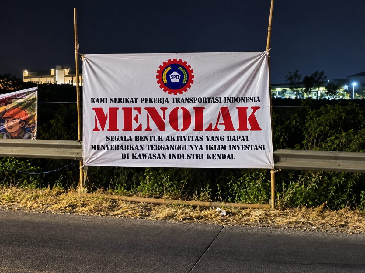Sepanduk penolakan demo terpasang di pinggir jalan kawasan KEK Kendal, Kamis (17/9/26). Foto: Ilustrasi AI