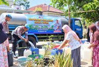 Warga Dukuh Bantul, Desa Kesesi, Kabupaten Pekalongan antre mengisi jeriken dengan air bersih bantuan Propam Polri, Senin (21/9/2026). Foto: Istimewa & AI