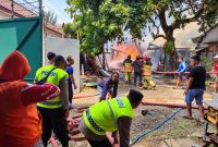 Petugas gabungan memadamkan kebakaran gudang kayu di Gembong Timur, Kelurahan Kedungwuni Timur, Kecamatan Kedungwuni, Kabupaten Pekalongan, Senin (21/9/26). Foto: Istimewa & AI