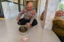 Polisi memperlihatkan panci berisi sisa bubur kacang ijo yang disantap warga di tiga RT di Desa Rowobelang, sebagai PMT dalam kegiatan Posyandu Mawar, Selasa (22/9/2026).
