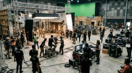 Kesibukan kru dalam produksi film di sebuah studio besar. Foto: Ilustrasi AI