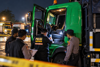 Petugas melakukan pemeriksaan di dalam kabin truk Hino yang dikemudikan Misru (59), sopir asal Kabupaten Lumajang, Jawa Timur, yang ditemukan meninggal dunia di pangkalan truk tepi Jalur Pantura, Desa Siwalan, Kabupaten Pekalongan, Kamis (29/10/2026) malam. (foto: ilustrasi AI)